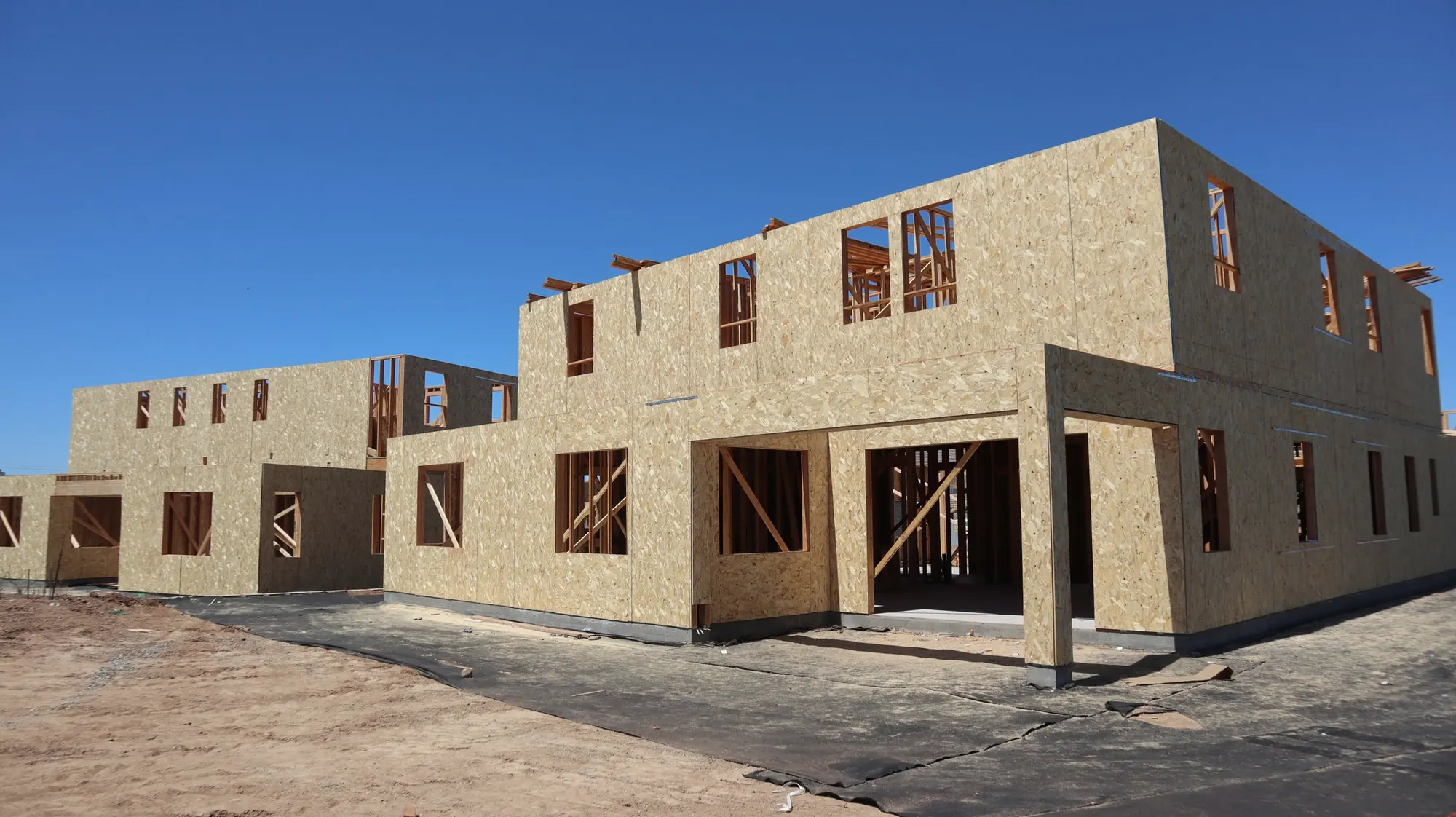 Two-storey stacked townhouse blocks framed and sheathed on a new residential site